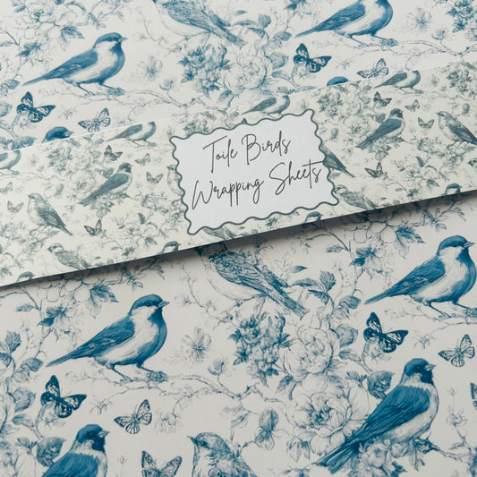 Roll of Toile Birds wrapping sheets with blue birds and flowers on a white background.