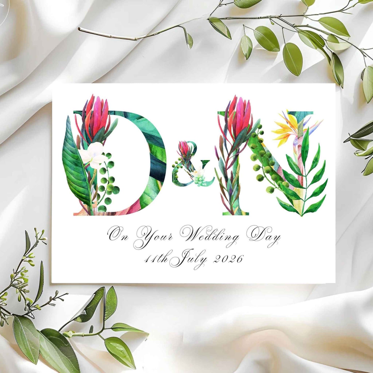 Wedding card with floral letters 'D' and 'N' on a white fabric background