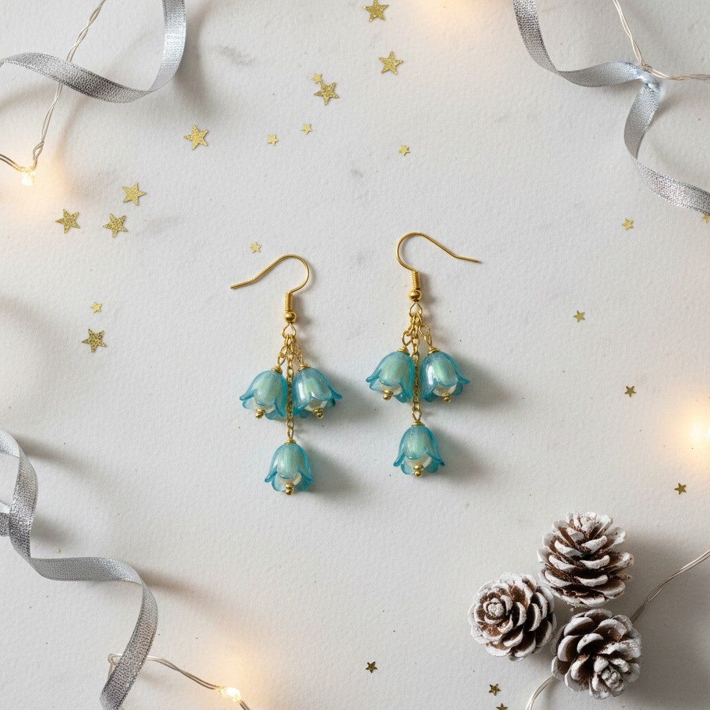 Pair of turquoise floral earrings on a decorative background with lights and pine cones.