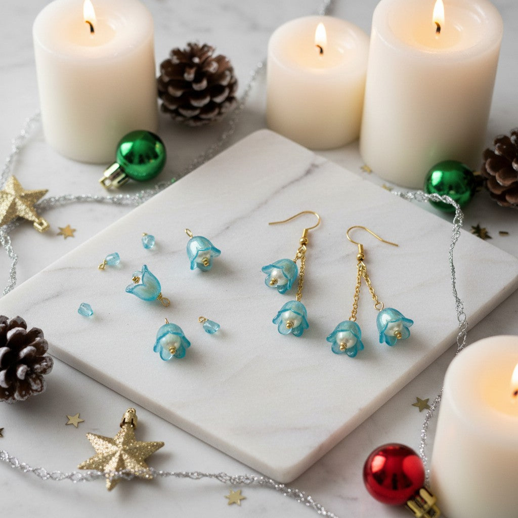Jewelry set with blue floral earrings on a marble surface with candles and Christmas decorations.