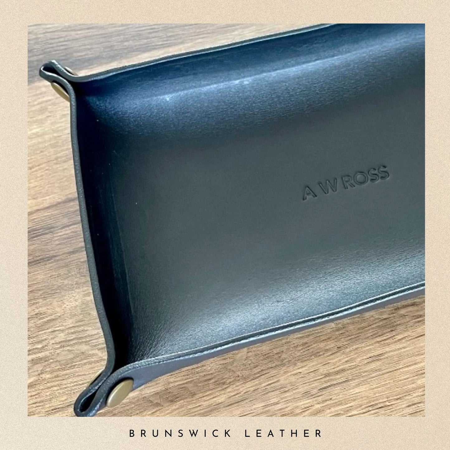 Blue leather pouch with 'A W Ross' branding on a wooden surface