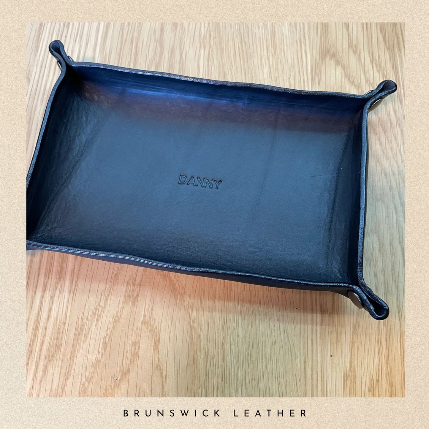 Blue leather tray with 'Bantry' branding on a wooden surface, featuring 'Brunswick Leather' text.