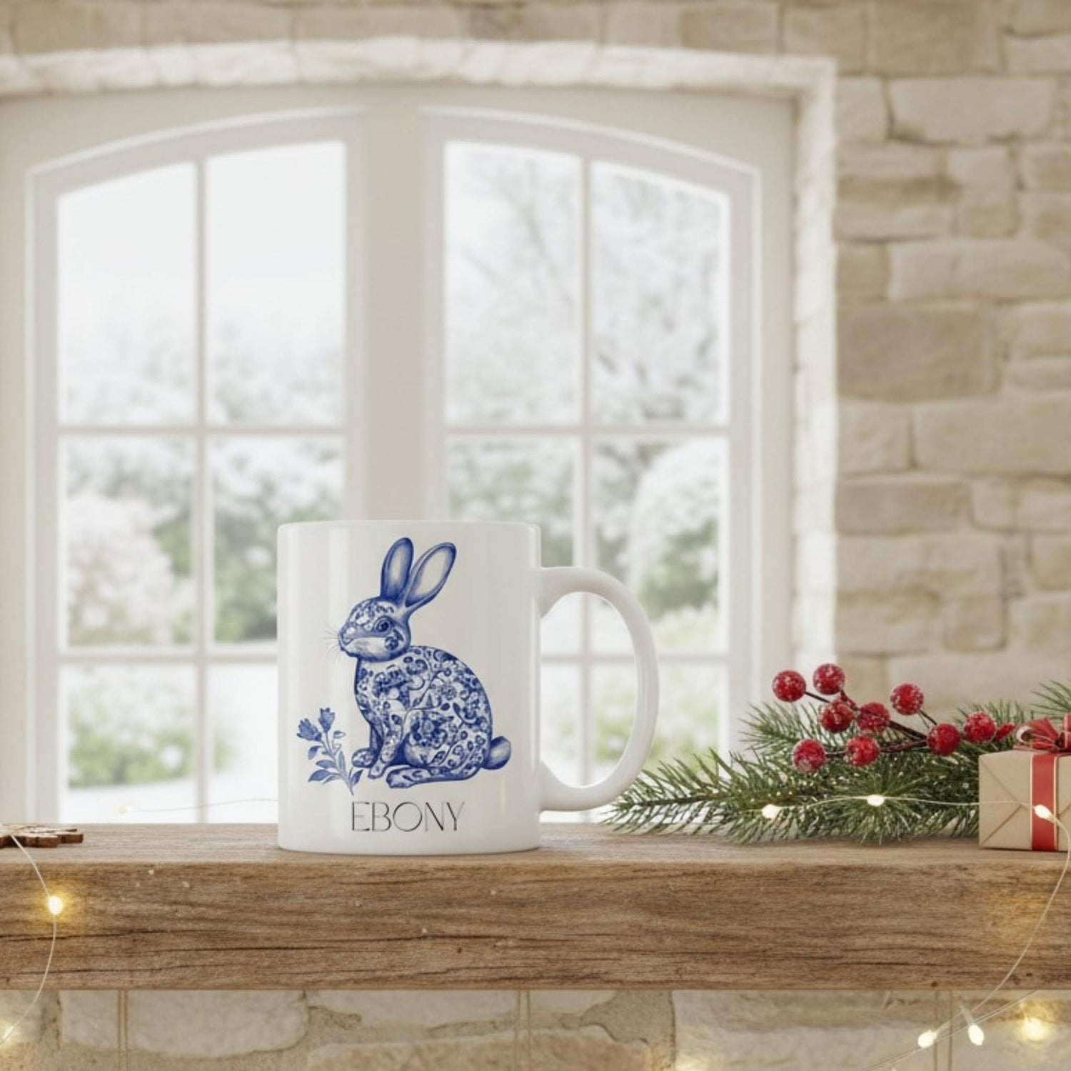 White mug with blue hare design on a wooden shelf with festive decorations