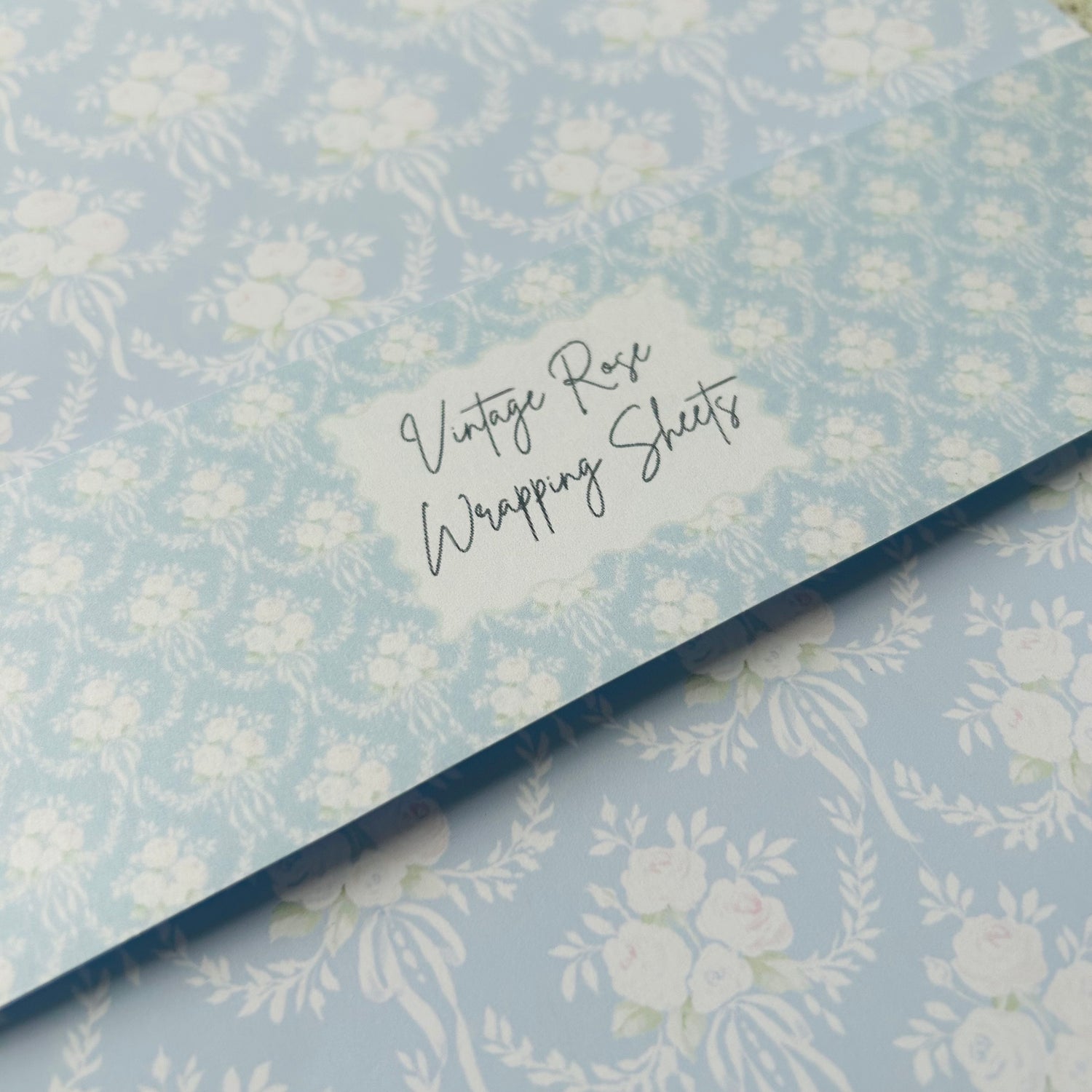 Floral-patterned wrapping paper with a label reading 'Vintage Rose Wrapping Sheets'.