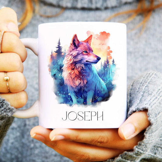 Mug with a colourful wolf design and 'JOSEPH' text held by hands.