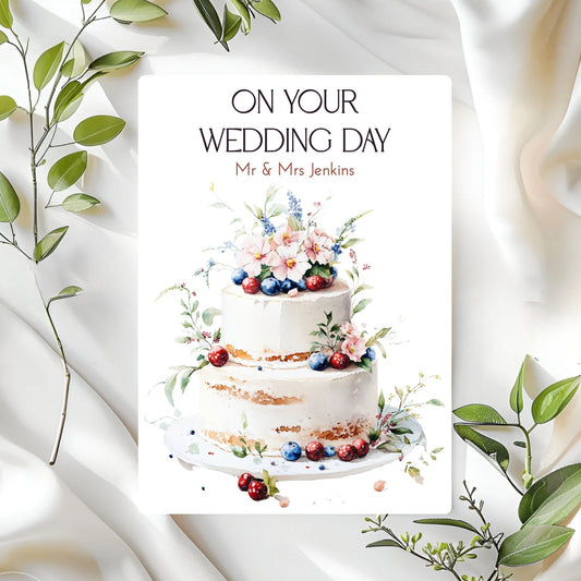 Wedding card with a cake illustration and 'On Your Wedding Day' text on a white background with green leaves.