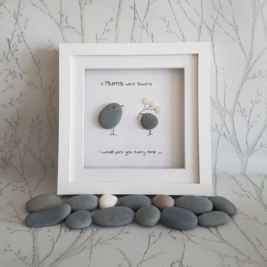 A white picture frame with a message 'If mums were flowers I would pick you every time.' inside, adorned with pebbles on the sides.