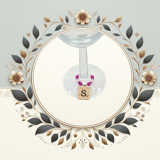 Wine glass charms with coloured beads and scrabble tile letter placed ona a wine glass stem. Image in a floral circle.