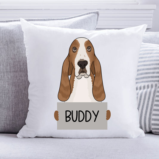 A square-shaped, white personalised pet cushion featuring an illustration of a basset hound dog with the name 'Buddy' printed on it.