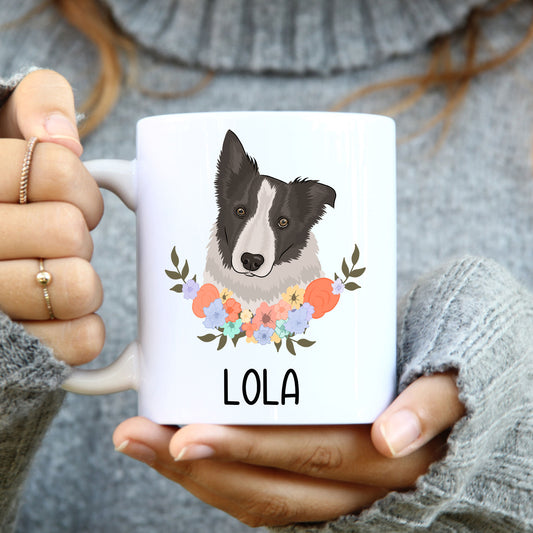 A person holding a white coffee mug with a printed Border Collie dog design and a floral pattern on the side.