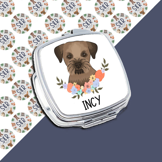 A personalised compact mirror with a Border Terrier dog illustration and a floral pattern on the front, with the name 'Incy'.