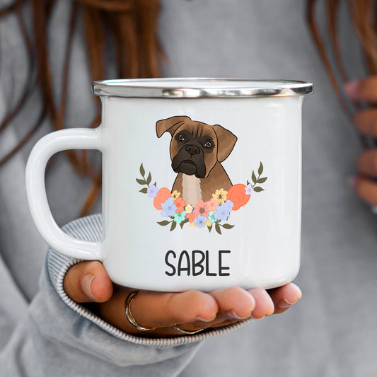 A white enamel mug with a colourful floral design and a graphic of a Boxer dog in the center. The mug has the text 'SABLE' on it.