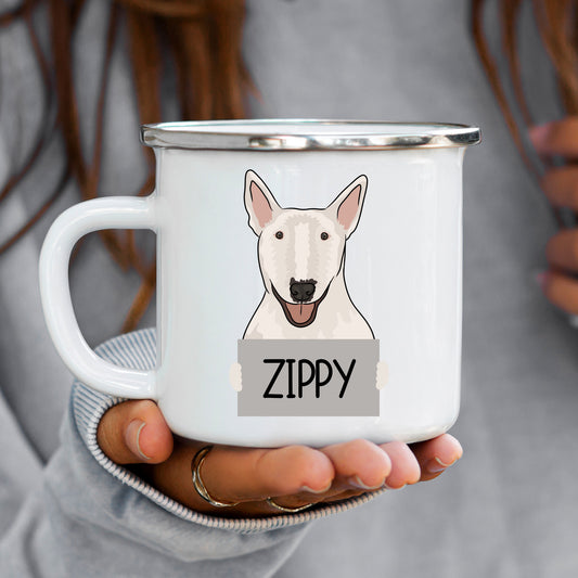A white enamel mug with a graphic of a Bull Terrier dog printed on it, held in a person's hand.