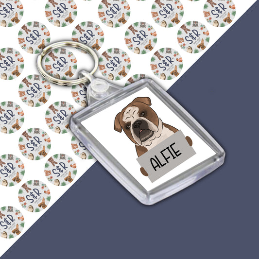 A personalised bulldog keyring with an acrylic casing, featuring an image of a bulldog dog and the name 'Alfie' printed on it.