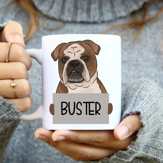 A person holding a white coffee mug with a colourful illustration of a bulldog on it.