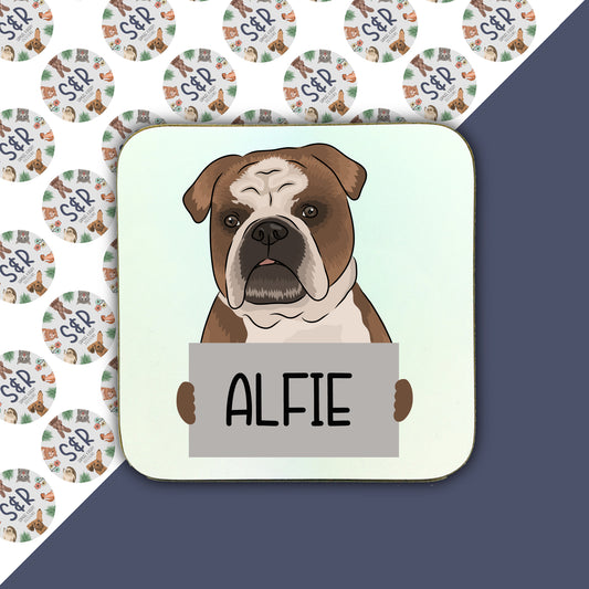 A square coaster with a personalised bulldog illustration in the center, with the name 'Alfie' below it. The background is white with decorative elements and text patterns.