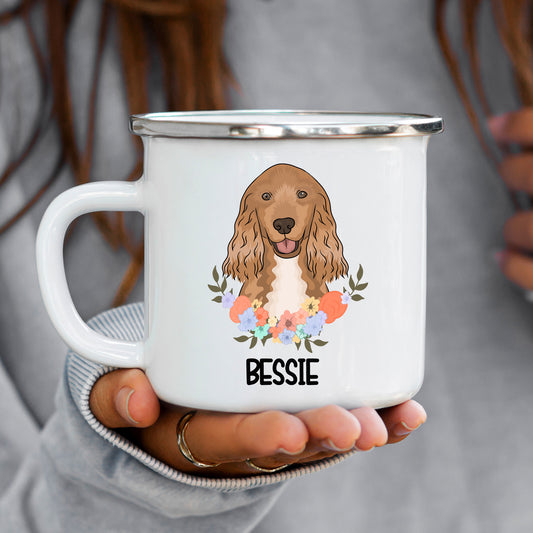 A white ceramic enamel mug with a printed illustration of a Cocker Spaniel dog surrounded by a floral pattern, with the name 'Bessie' at the bottom.