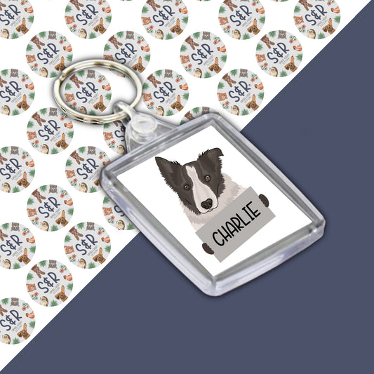 A personalised keyring featuring an illustration of a Border Collie dog with the name 'Charlie' printed on it, enclosed in a clear acrylic case.
