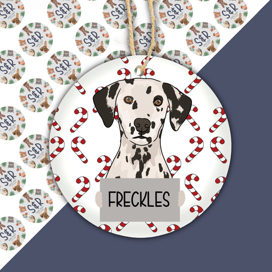 A ceramic Christmas ornament featuring a Dalmatian dog with a glossy finish, surrounded by red and white striped decorations, with the text 'DALMATIAN' and 'FRECKLES' on the ornament.