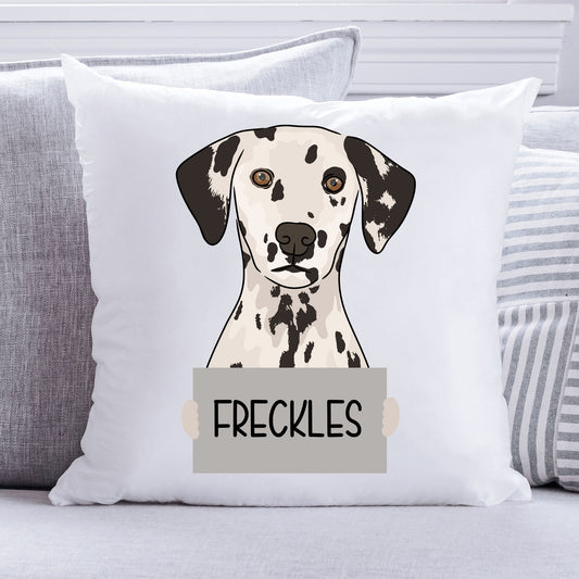 A square-shaped cushion with a print of a Dalmatian dog's head with the name 'Freckles' below it.