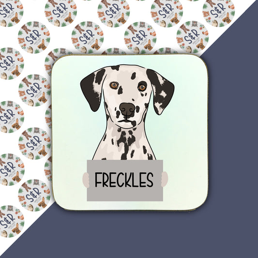 A square coaster with a personalised design featuring an illustration of a Dalmatian dog, with the name 'FRECKLES' below it.