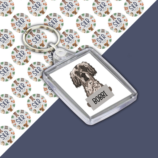 A personalised double-sided keyring with an image of an English Setter dog on a clear acrylic casing, featuring the name 'BOBI' on the front.