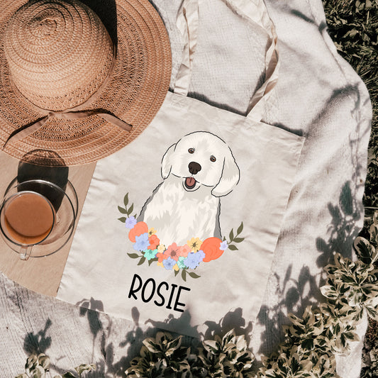 A white tote bag with a printed image of an English Sheepdog surrounded by a floral wreath, with the name 'ROSIE' printed on the front.