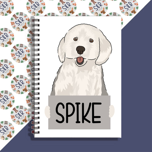 A notebook with a spiral binding featuring a cartoon illustration of an English Sheepdog on the cover, with the text 'Spike' on a label.