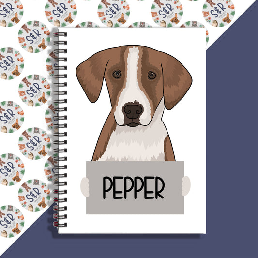 A notebook with a spiral binding featuring a graphic of a foxhound dog on the front cover, labeled with the breed name 'PEPPER'.