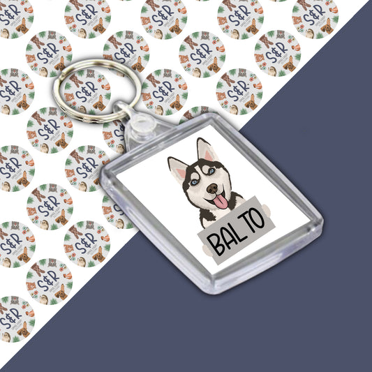 A personalised keyring featuring an illustration of a husky dog on a clear acrylic casing with the name 'BALTO' below the image.