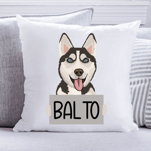 A square-shaped cushion with a white background featuring an illustration of a Husky dog with the text 'BALTO' on a sign it is holding.