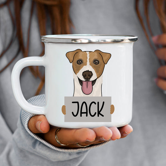 A white ceramic enamel mug with a graphic of a Jack Russell dog printed on it, held in a person's hand.