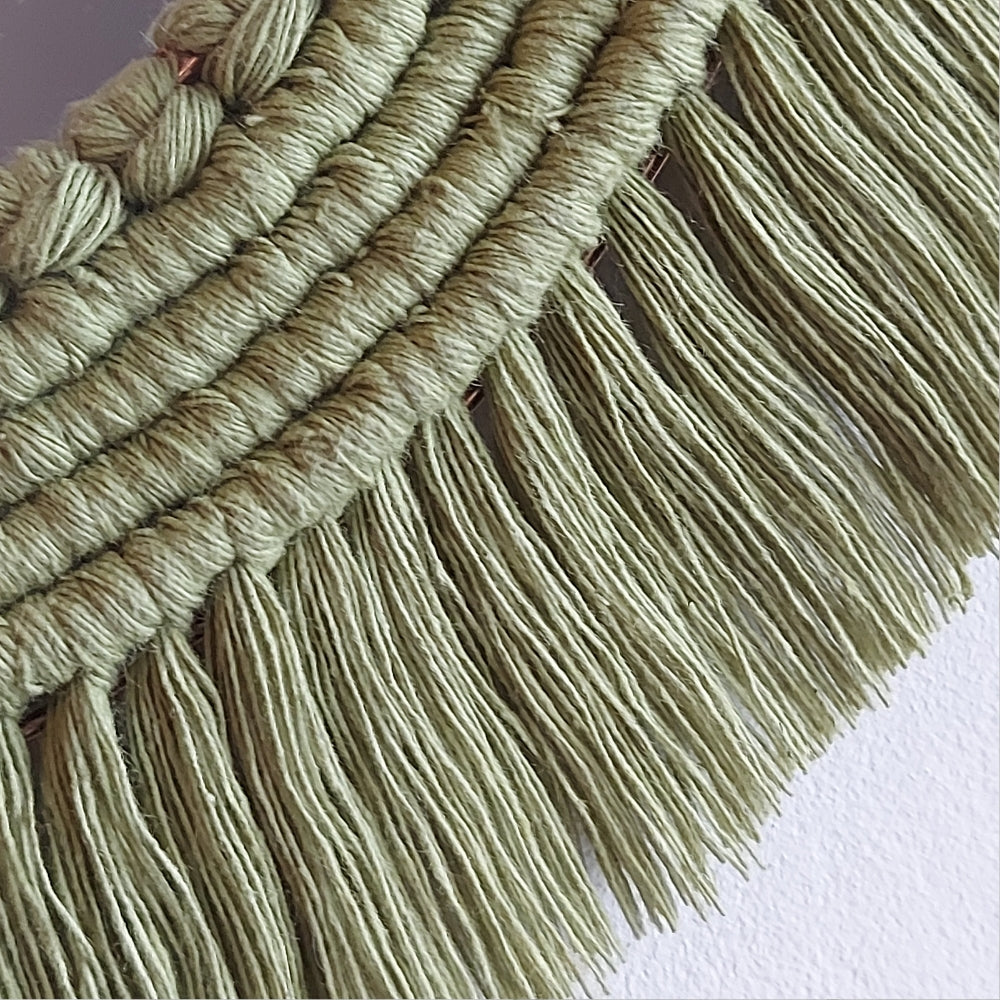 Close up detailing of the fringe of a macrame mirror