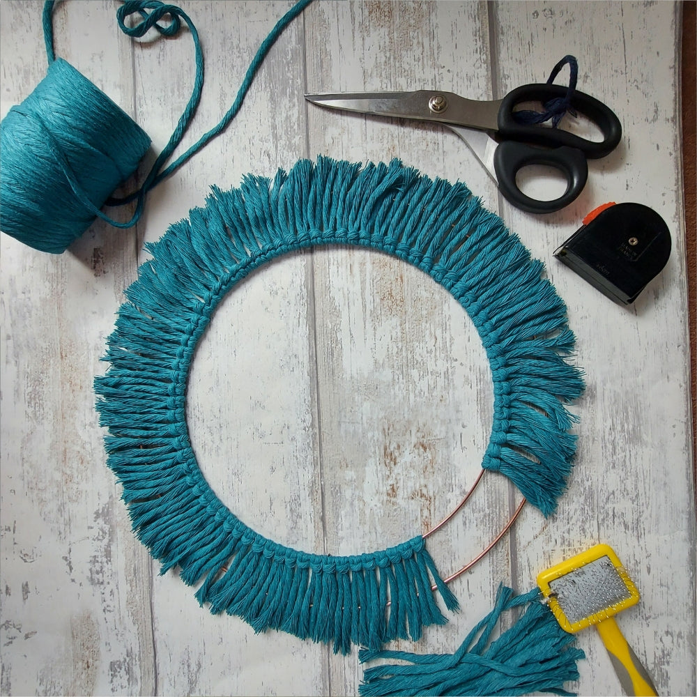 Showing a macrame wall mirror in progress, handmade macrame mirror with scissors and macrame yarn