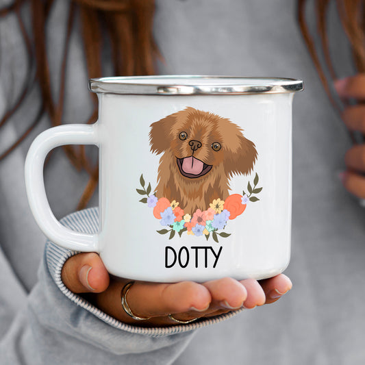 A white enamel mug with a printed illustration of a Pekingese dog surrounded by a floral wreath, with the text 'Dotty' at the bottom.