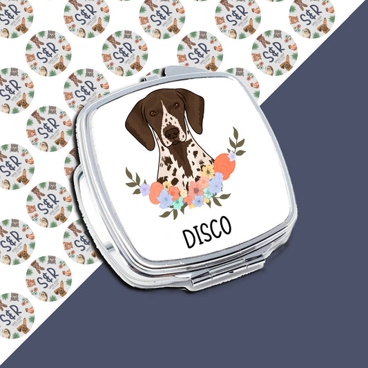 A personalised compact mirror with a sublimated design featuring a pointer dog surrounded by a floral pattern, with the word 'DISCO' below the image.