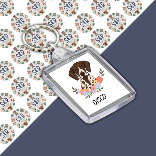 A personalised double-sided acrylic keyring featuring an illustration of a dog with the name 'Disco' on a branded Samuel & Rigby designs backing card.