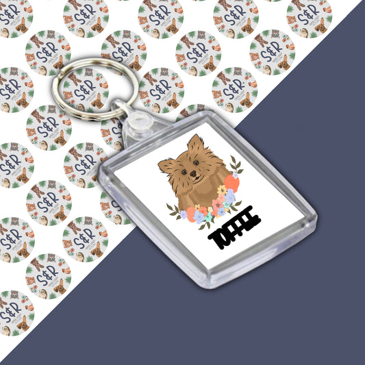 A Pomeranian dog keyring with a double-sided design, personalised dog keyring, displayed on a branded Samuel & Rigby designs backing card.