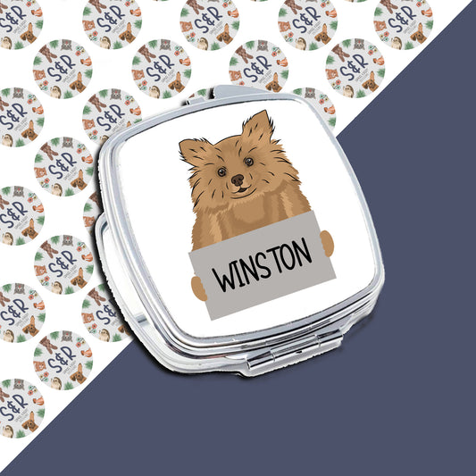 A compact mirror with a sublimated design of a Pomeranian dog on a background with the text 'WINSTON'.