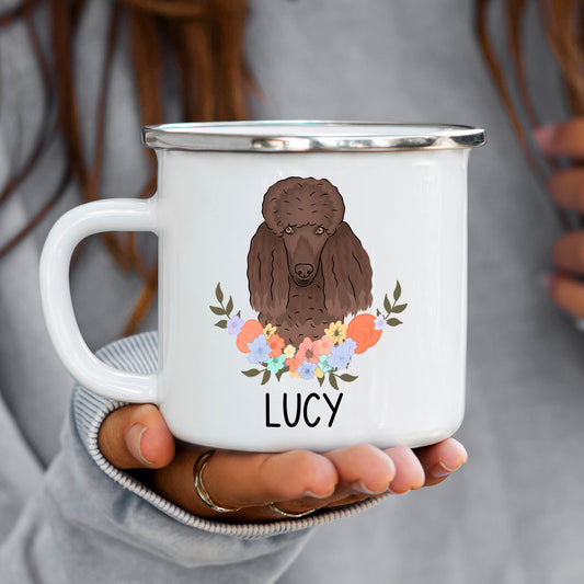 A white enamel mug with a colourful illustration of a poodle dog surrounded by a floral pattern, with the name 'LUCY' inscribed on the mug.