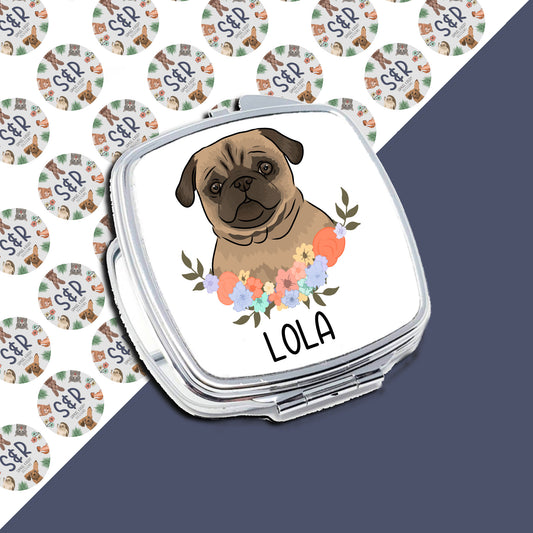 A personalised compact mirror with a design of a pug dog surrounded by a floral pattern, with the name 'Lola' printed on the front.