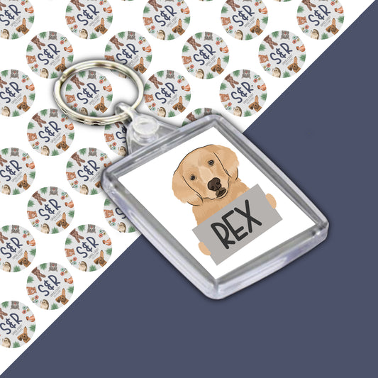 A personalised keyring featuring an illustration of a golden retriever dog with the name 'Rex' on a clear acrylic backing card.
