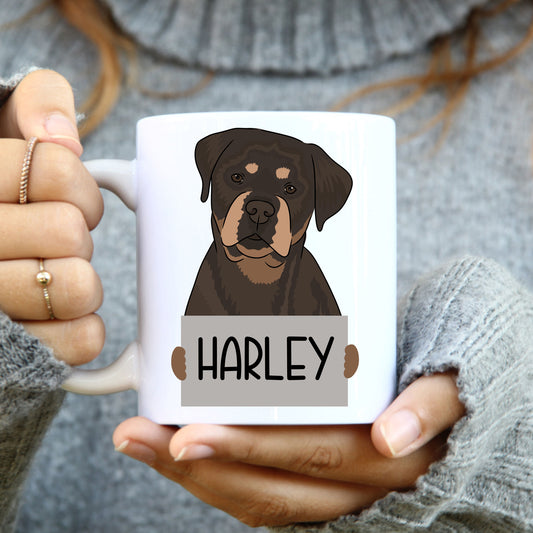 A person holding a coffee mug with a graphic of a Rottweiler dog on it, with the name 'Harley' printed below the image.
