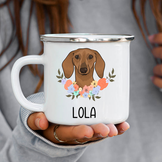 A white enamel mug with a printed design of a sausage dog (dachshund) with a floral pattern.