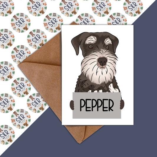 A handmade card featuring an illustration of a Schnauzer dog with the name 'PEPPER' written on the front, along with a brown manilla envelope.