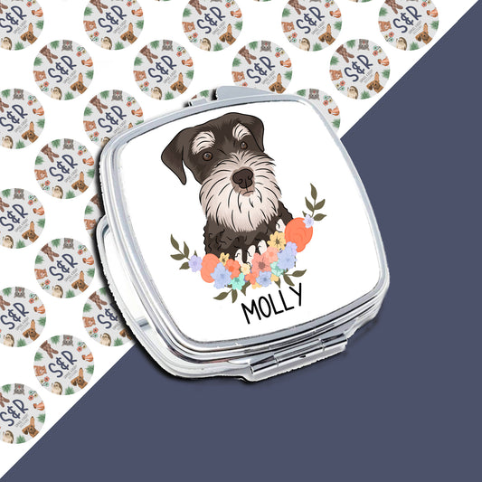Compact mirror with a personalised design featuring a black and white schnauzer dog at the center, surrounded by a floral pattern, with the name 'Molly' printed on the mirror.