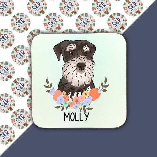 A square coaster with a colourful floral pattern and a central illustration of a Schnauzer dog. The coaster has the name 'Molly' written on it.