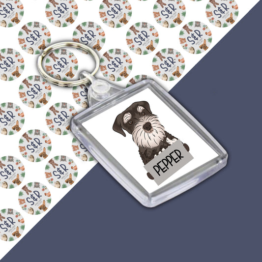 A personalised Schnauzer keyring with an acrylic casing, featuring an illustration of a dog on a round keyring.