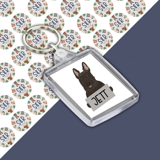 A personalised keyring featuring an image of a Scottish Terrier dog with the name 'Jett' printed on it, encased in a clear acrylic shell.