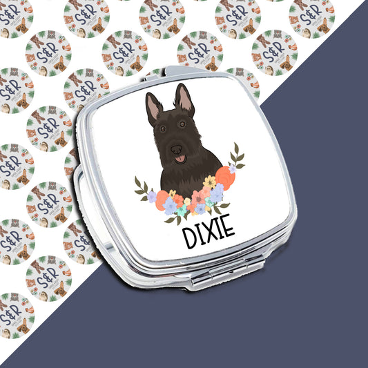 A personalised compact mirror with a Scottish Terrier dog illustration and a floral border on a white background.